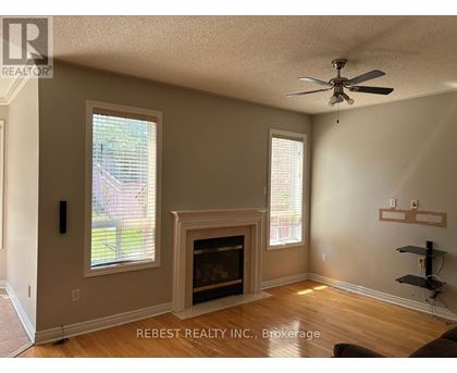 A room with a fireplace and a ceiling fan.