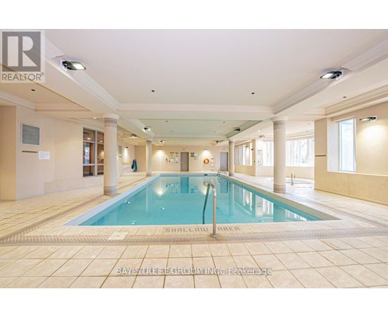 A large indoor swimming pool with a tiled floor and walls.