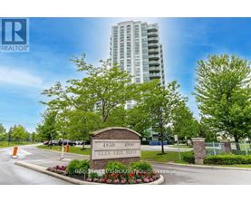 A sign for Glen Erin Drive is in front of a tall building.