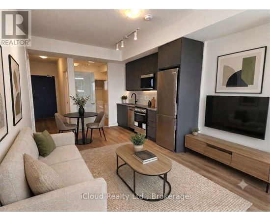 A modern living room with a beige sofa, a black coffee table, and a flat-screen TV.
