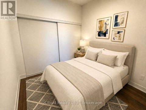A bedroom with a large bed and a lamp on the side table.