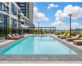 A large swimming pool with lounge chairs and a sign that says "Shallow Area, No Diving 1.3m" in front of a building.