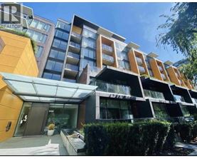 A modern multi-story building with a glass entrance and a sign that reads "REALTOR".