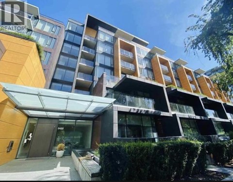 A modern multi-story building with a glass entrance and a sign that reads "REALTOR".