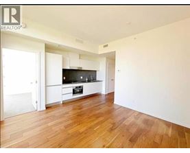 A spacious room with wooden flooring and a television.