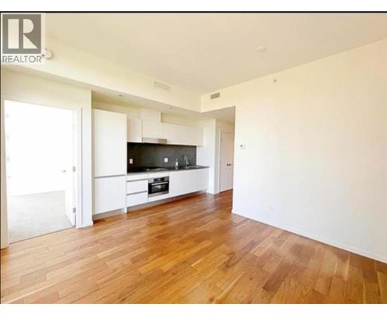 A spacious room with wooden flooring and a television.