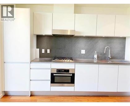 A modern kitchen with white cabinets and a stainless steel oven.