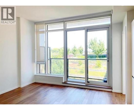 A room with a large window and wooden flooring.