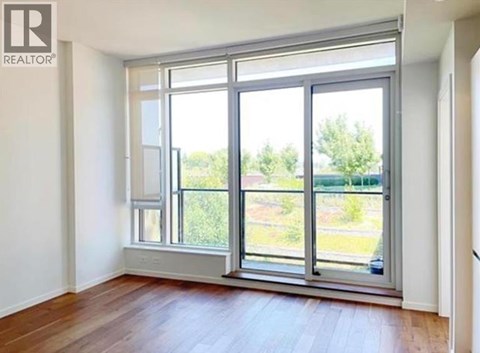 A room with a large window and wooden flooring.