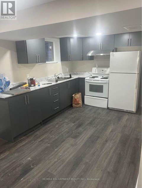 A kitchen with a white fridge and black cabinets.