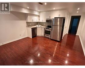 A kitchen with stainless steel appliances and wooden floors.