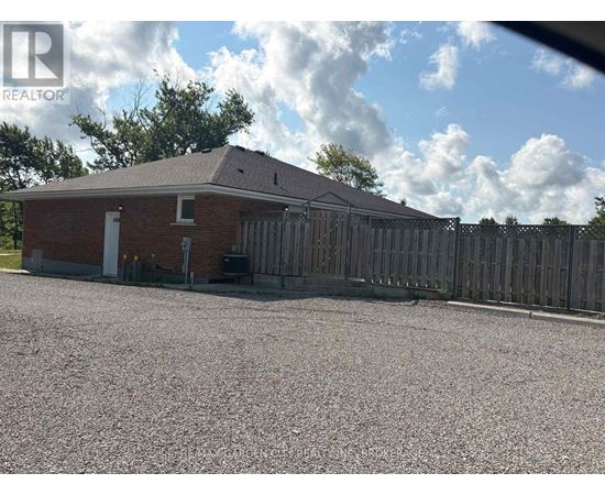 A house with a gravel driveway and a wooden fence.