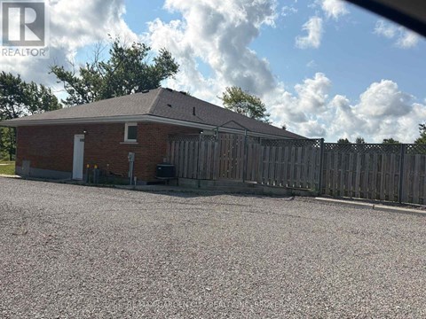 A house with a gravel driveway and a wooden fence.