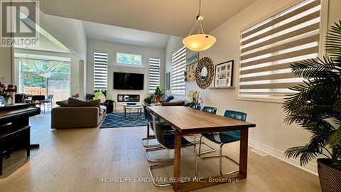 A well-lit living room with a dining table and chairs.