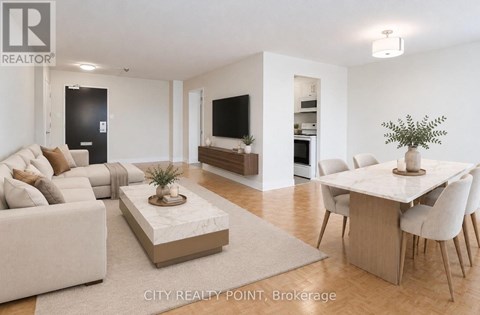 A living room with a white couch, a coffee table, and a dining table with chairs.