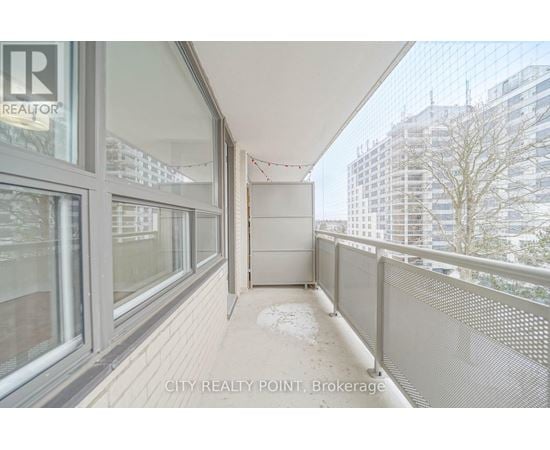 A balcony with a railing and a view of buildings in the distance.