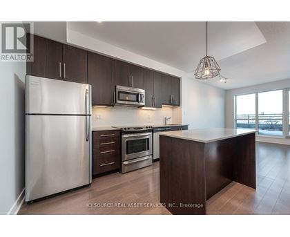 A modern kitchen with dark brown cabinets and stainless steel appliances.