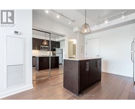 A modern kitchen with dark wood cabinets and a white interior.