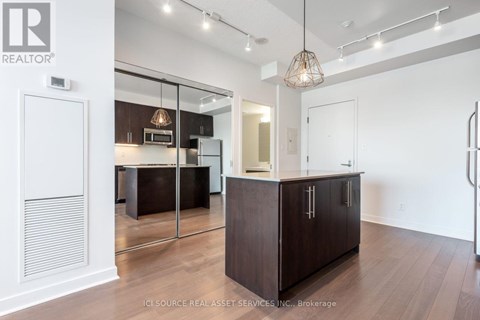 A modern kitchen with dark wood cabinets and a white interior.
