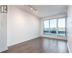 A room with a large window and wooden flooring.