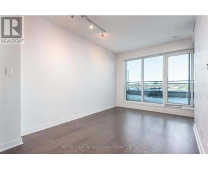 A room with a large window and wooden flooring.