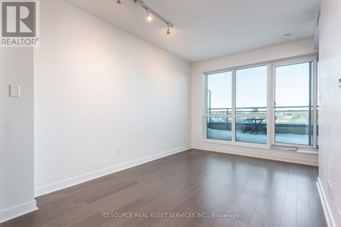 A room with a large window and wooden flooring.