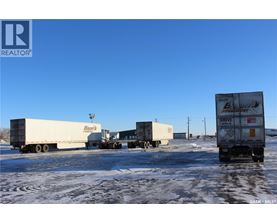 Four semi trucks are parked in a lot.