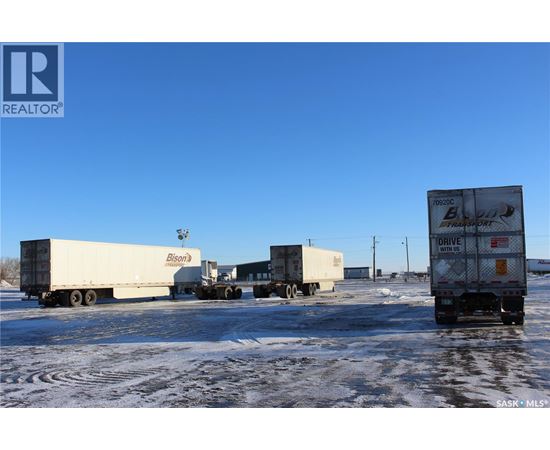 Four semi trucks are parked in a lot.