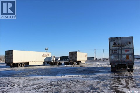 Four semi trucks are parked in a lot.