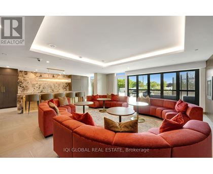 A modern living room with red sofas and a stone wall.