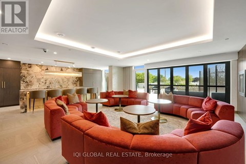A modern living room with red sofas and a stone wall.