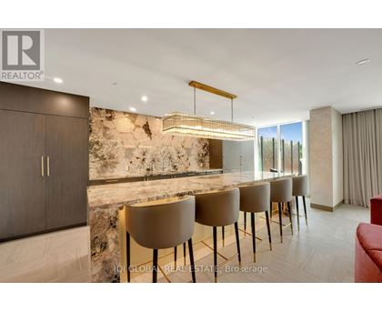 A modern dining room with a stone wall and a long table with chairs.