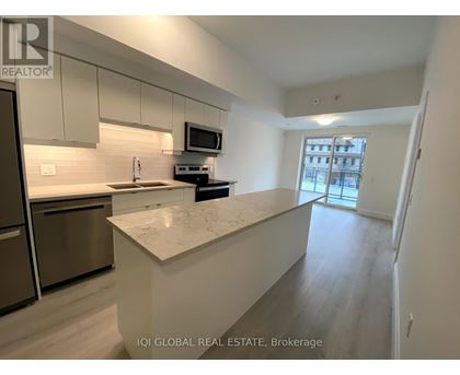 A kitchen with a refrigerator, microwave, and stove top oven.