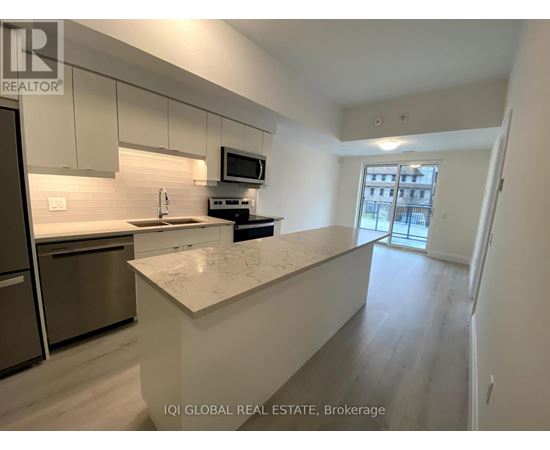 A kitchen with a refrigerator, microwave, and stove top oven.