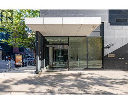 The image shows the front of a building with a glass entrance and a sign that reads "77 Shuter Street".