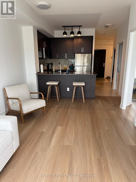 A modern kitchen with a bar stool and a chair.