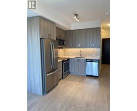 A modern kitchen with stainless steel appliances and wooden cabinets.