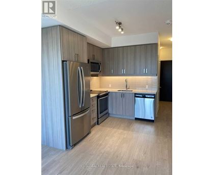 A modern kitchen with stainless steel appliances and wooden cabinets.