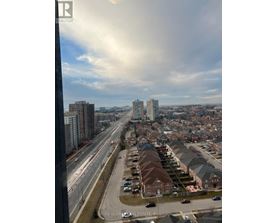 A view from a high-rise building looking down at a residential area with houses and a highway.