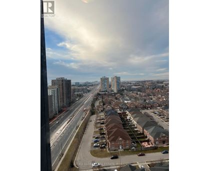 A view from a high-rise building looking down at a residential area with houses and a highway.