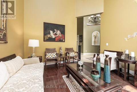 A living room with a couch, chairs, and a painting on the wall.
