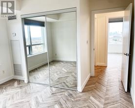 A bedroom with a sliding glass door leading to a balcony.