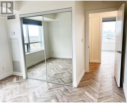 A bedroom with a sliding glass door leading to a balcony.