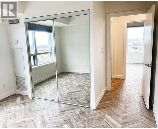 A bedroom with a sliding glass door leading to a balcony.
