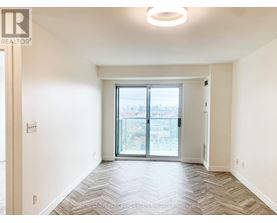 A spacious, empty room with a large window and sliding glass doors.