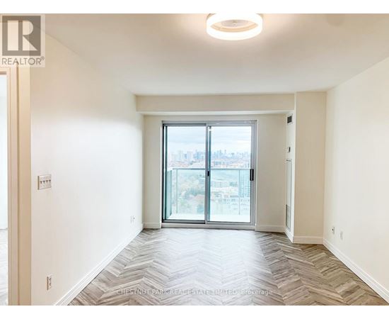 A spacious, empty room with a large window and sliding glass doors.