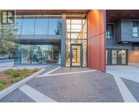 The image shows the front of a building with a glass facade and a red pillar with the number 28 on it.