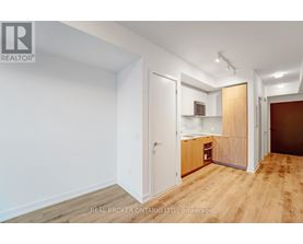 A room with a white wall and a wooden floor.