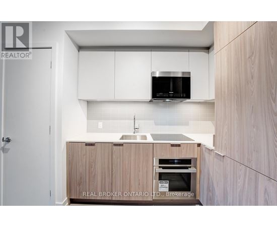 A modern kitchen with wooden cabinets and a white countertop.