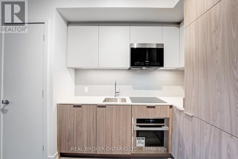 A modern kitchen with wooden cabinets and a white countertop.